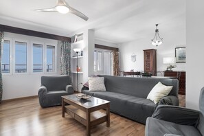 A living room with a sofa, armchairs, a coffee table, and a dining area with a table and chairs. - Apartment 'Miramar' with Sea View, Wi-Fi and Air Conditioning (Barbate)