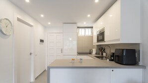 A modern kitchen with white cabinetry, a built-in microwave, and a coffee machine. - Vacation 'The Dorado 206' with Shared Pool, Shared Terrace and Wi-Fi (Arona)
