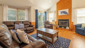Ein geräumiges Wohnzimmer mit Kamin, Ledersofas und Holzboden.