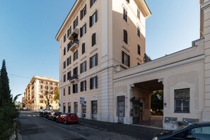 A multi-story building with a flat facade, a ground-level entrance, and a visible balcony on the second floor.
