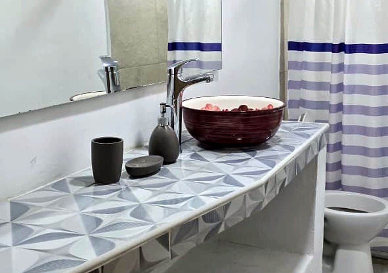 Un bagno con un lavandino moderno, uno specchio e un water.