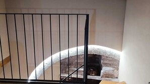Una escalera con barandilla de metal que conduce a un muro de piedra.