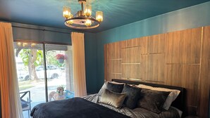 Une chambre à coucher avec un grand lit, une tête de lit en bois et un lustre.