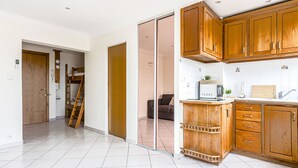 A modern kitchen with wooden cabinets, a built-in microwave, and a sink. - Le Mirazur by Interhome (Nice)