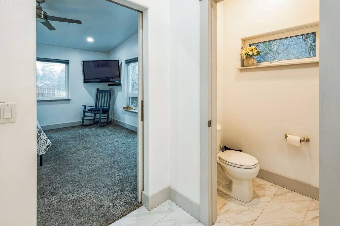Une pièce équipée d’une télévision, d’une chaise, d’une fenêtre et de toilettes.