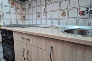 A kitchen with a countertop, sink, and stove. - 209A Apartamento Bedriñana (Villaviciosa)