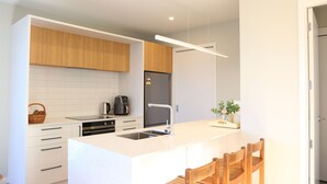 Una cocina moderna con armarios blancos, una isla central y horno empotrado.