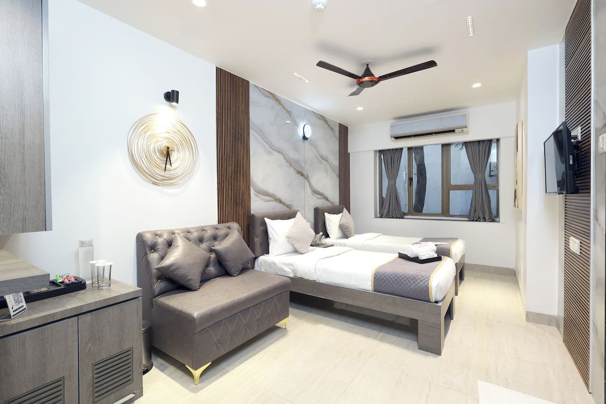 Un dormitorio moderno con cama, sofá, escritorio y ventilador de techo.