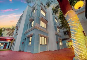 A multi-story building with a modern architectural design, featuring large windows and a red brick ground floor. - Myotel - Santacruz (Mumbai)