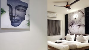 Un dormitorio moderno con una cama, ventilador de techo y pared de mármol.