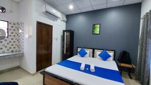 Una habitación de hotel con cama, armario, escritorio y ventana.