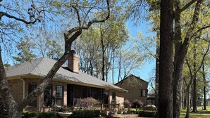 A two-story house with a brick exterior, a covered porch, and a well-maintained lawn. - 3-bedroom golf course home on Walden on Lake Conroe Montgomery with WiFi, AC (Montgomery)