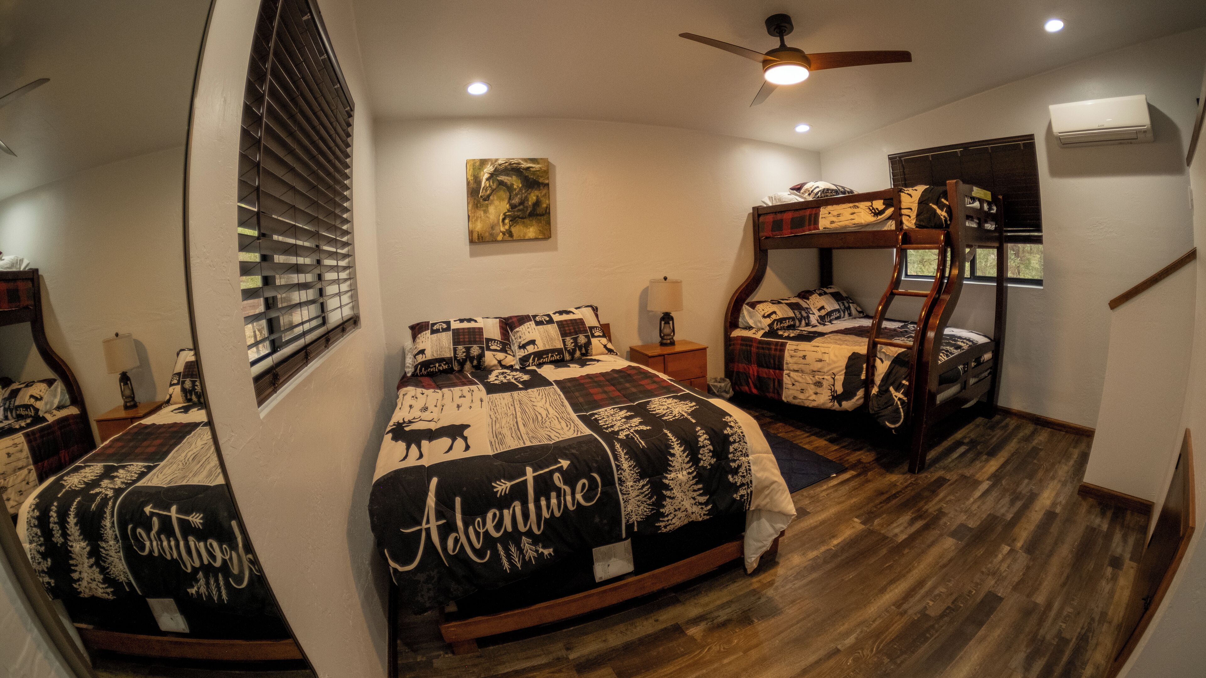 A bedroom with two bunk beds, a ceiling fan, and a window with blinds.