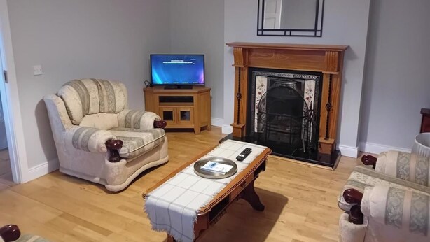 Una sala de estar con un sofá, una mesa de centro, un televisor y una chimenea.