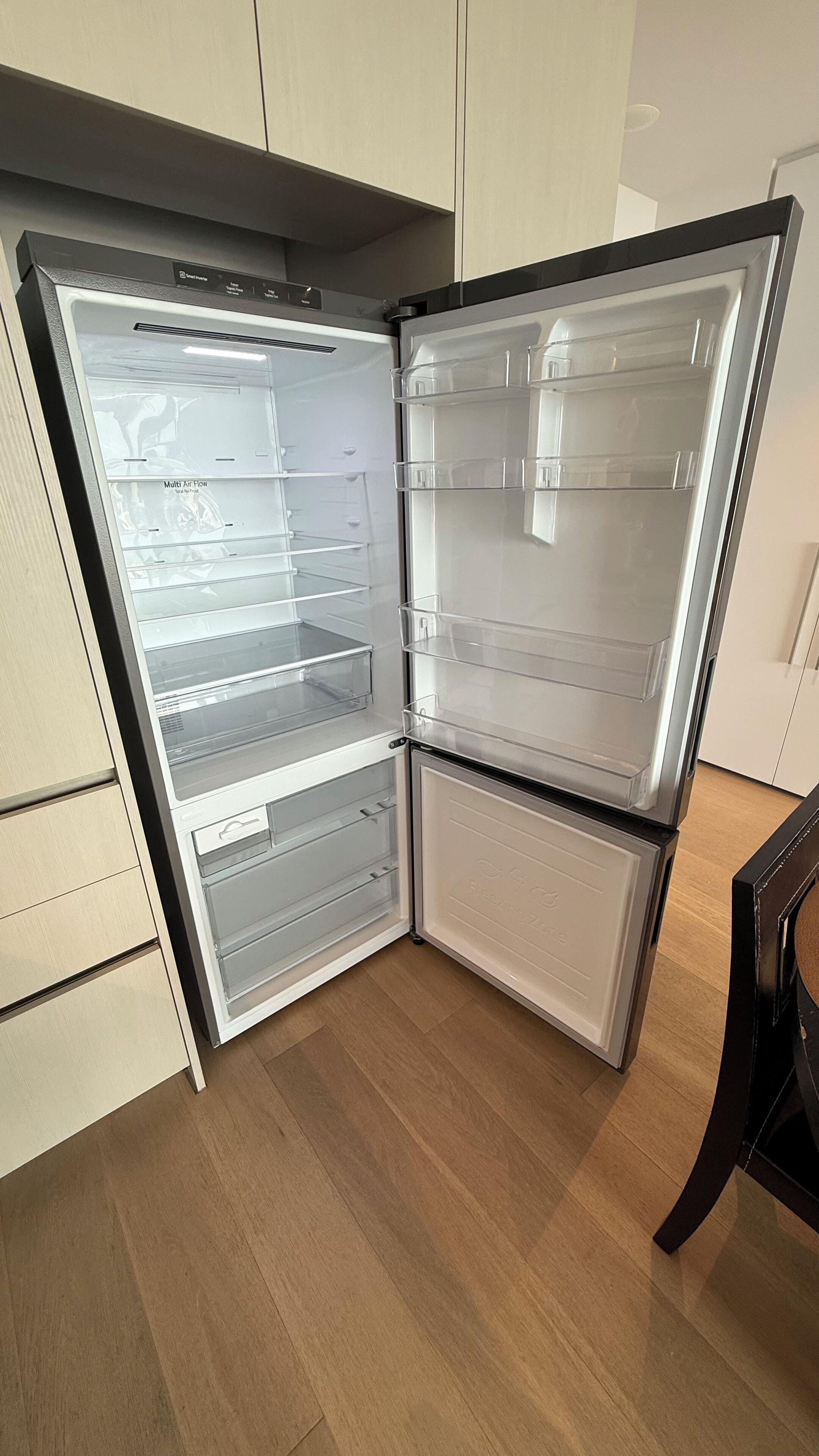 A modern kitchen with a built-in refrigerator and a microwave.
