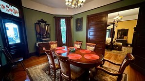 A dining room with a wooden table, chairs, and a chandelier. - Pinwheel Place off the Square (Talladega)