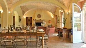 A spacious dining area with a high arched ceiling, a fireplace, and a view of the outdoors. - Villa Teresina - Guardistallo, Pisa (Guardistallo)