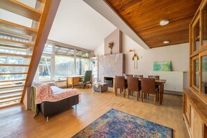 A spacious room with a loft bed, a dining area, and a fireplace. - Family private house, 400m to the beach (Jurmala)