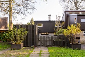 A modern two-story house with a dark exterior, a visible chimney, and a gated entrance. - Family private house, 400m to the beach (Jurmala)