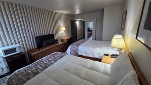 Ett hotellrum med två sängar, en TV, en mikrovågsugn och ett skrivbord.