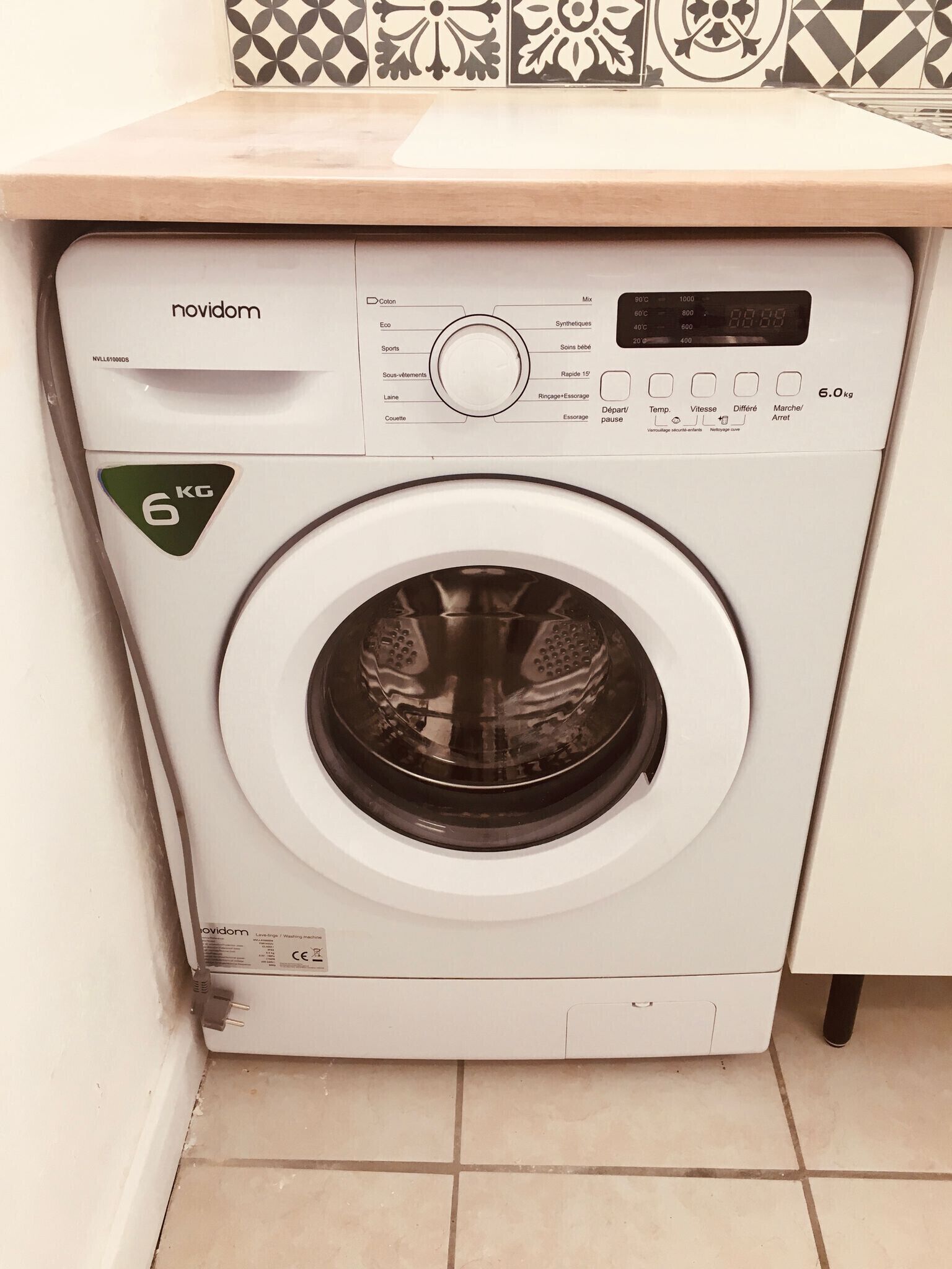 A front-loading washing machine with a control panel, a 6 kg capacity indicator, and a CE mark.