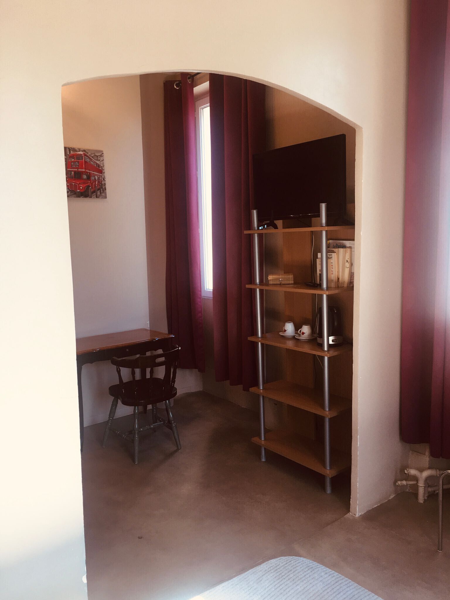 Habitación de esquina con escritorio, silla y estantería empotrada.