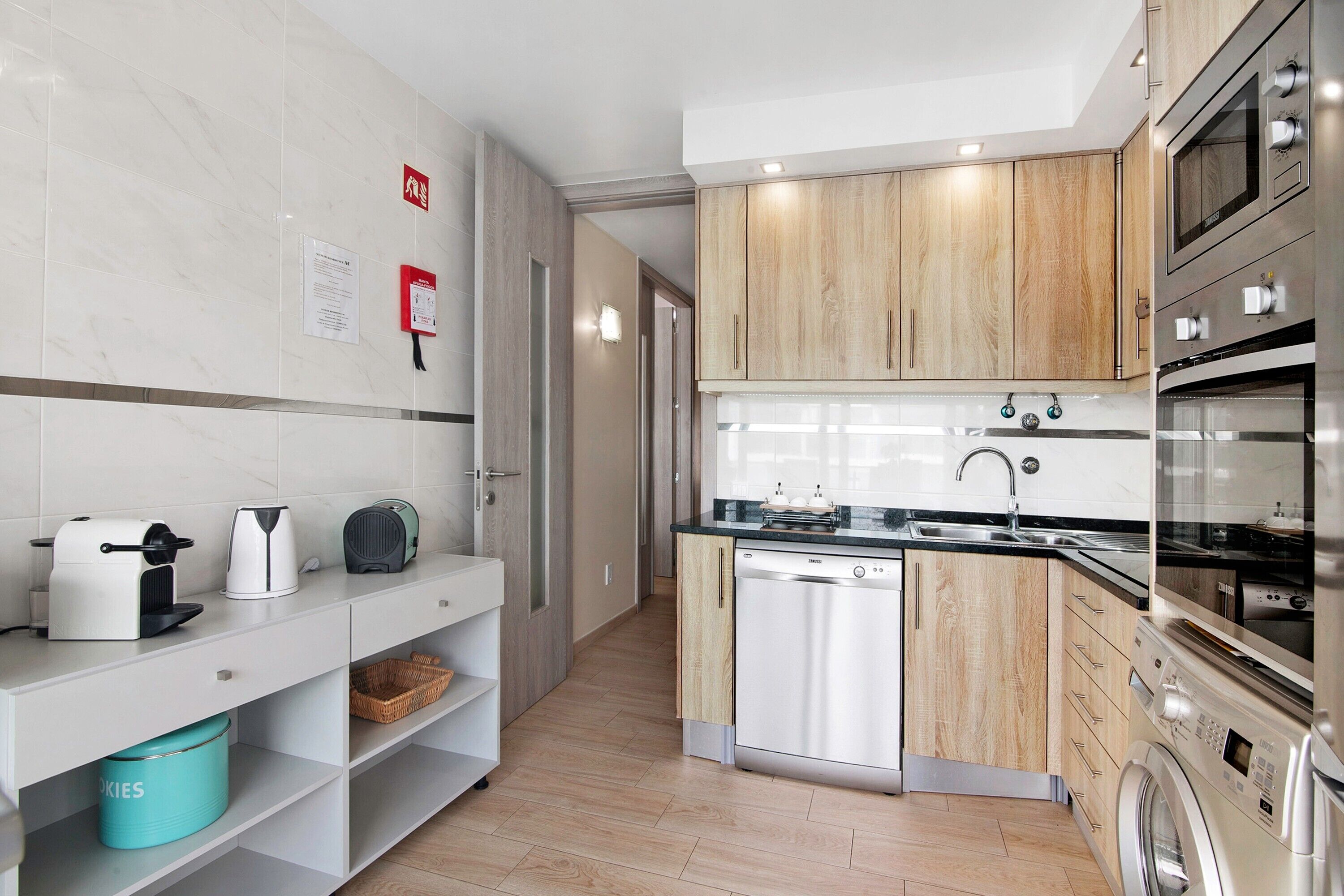 A modern kitchen with a dishwasher, oven, and microwave.