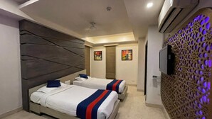 Een hotelkamer met twee bedden, een modern design en een decoratieve wand met een geometrisch patroon.