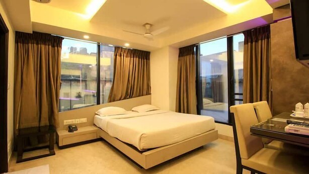 Een moderne hotelkamer met een bed, een bureau en een stoel.