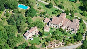 An aerial view of a property with a swimming pool, stone buildings, and well-maintained gardens. - Borgo  Fastelli - FASTELLI OLMO (Sarteano)
