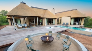 Ein Resort mit Pool, Außensitzgelegenheiten und Feuerstelle.