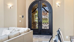 Un intérieur moderne avec une grande porte en arc de cercle, un mur de couleur beige et un canapé de couleur claire.