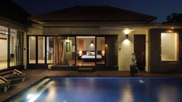 A modern hotel with a swimming pool, a bedroom with a large bed and a bathroom with a stone wall. - Jayani Villa (Seminyak)