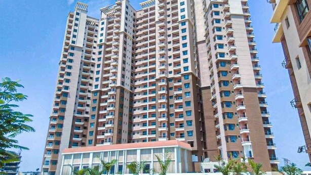 A high-rise residential building with multiple balconies and a central courtyard.