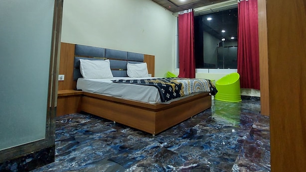 Ein Schlafzimmer mit einem Bett, einem Deckenventilator und einem roten Vorhang.