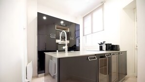 Eine moderne Küche mit einer zentralen Kochinsel, integrierten Geräten und einem großen Fenster.