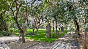 A pathway lined with trees and a tiled walkway.