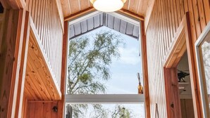A wooden interior with a large skylight and a hanging light fixture.