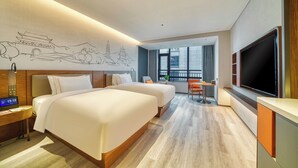A hotel room with two beds, a desk with a clock, a TV, and a large window with a view of the city. - UrCove by Hyatt Quzhou Changshan (Quzhou)