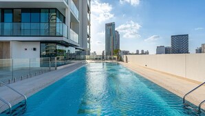 Une piscine sur le toit, avec la vue sur les toits de la ville en arrière-plan.