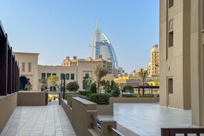 Un área urbana moderna con un edificio curvo destacado al fondo, probablemente un hotel o hito.