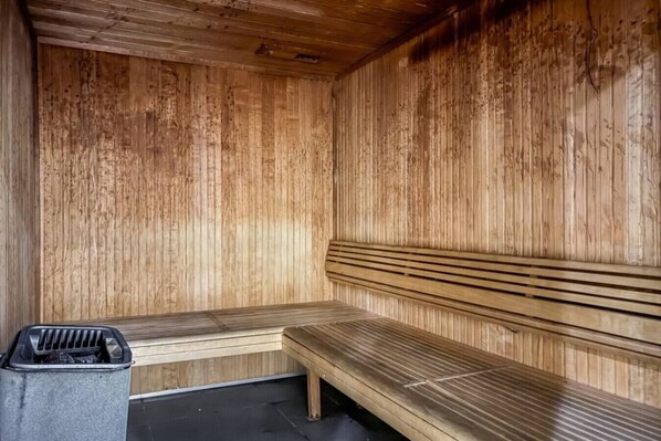 Un sauna avec des murs et des bancs en bois.