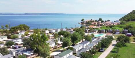 Zona residencial costera con casas móviles, piscina y vistas al mar.