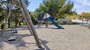 Un patio de recreo con columpios y un tobogán.