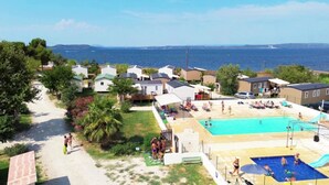 Zona residencial costera con varias casas, una piscina y vista al mar.