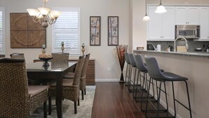 A modern kitchen with white cabinets, a stainless steel microwave, and a granite countertop. - Fairways at Mauna Lani Unit 1405 Garden View 3 Bed (Waimea)
