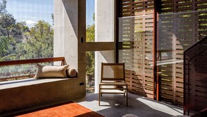 A modern interior with a large window, a wooden ceiling, and a seating area with a sofa and a chair.