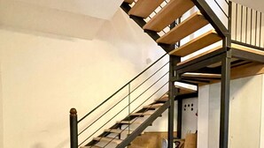 Un escalier avec un sol à carreaux et une rampe en métal.