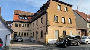 Un immeuble à plusieurs étages, doté d’une façade beige, de nombreuses fenêtres et d’une petite entrée avec des marches.