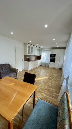 Un appartement moderne comprenant un coin repas, une cuisine et un espace de vie.